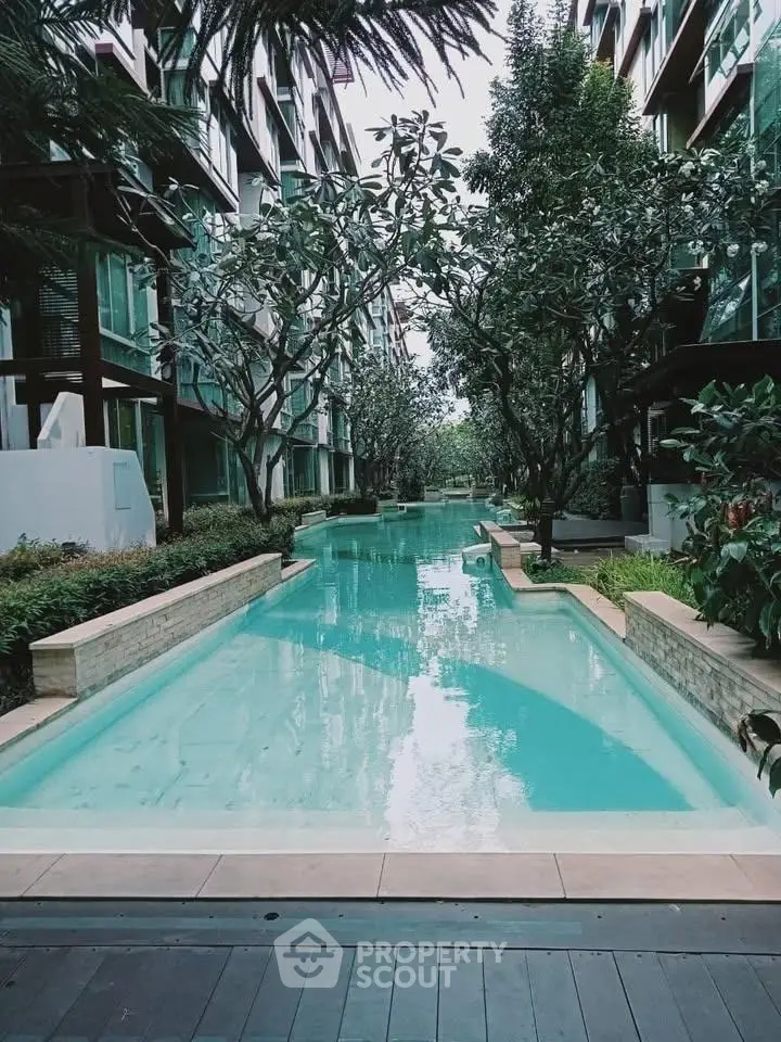 Luxurious residential pool surrounded by lush greenery and modern architecture, offering a serene oasis in the city.