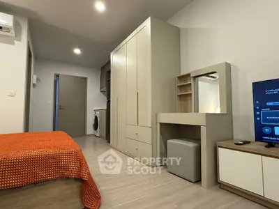 Modern studio apartment with stylish furniture and compact kitchen area.