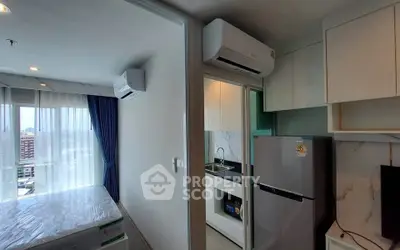 Modern apartment with compact kitchen and bright living area, featuring air conditioning and large windows.