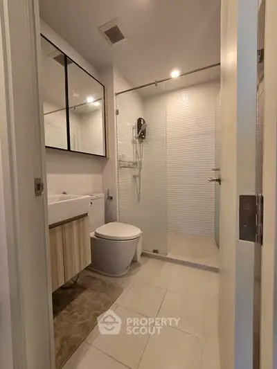 Modern bathroom with glass shower and sleek fixtures in a contemporary apartment.