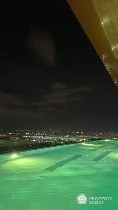 Stunning night view from rooftop with city skyline and illuminated pool