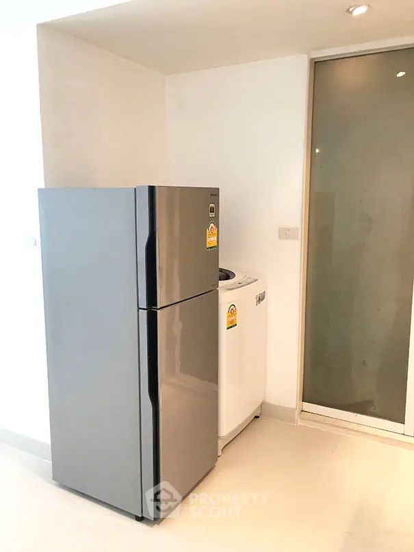 Modern kitchen corner with sleek fridge and washing machine
