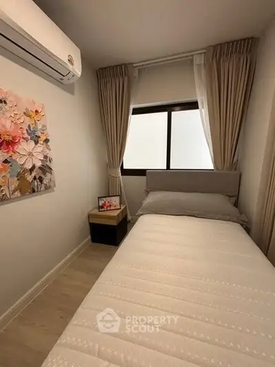 Cozy bedroom with modern decor and air conditioning, perfect for relaxation.