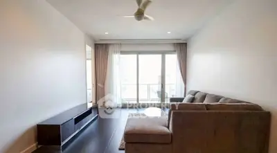Spacious living room with modern sofa and large window balcony view.