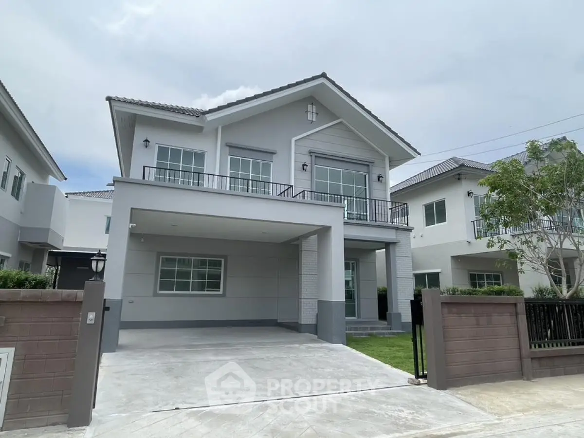 Modern two-story house with spacious driveway and manicured lawn in suburban neighborhood.