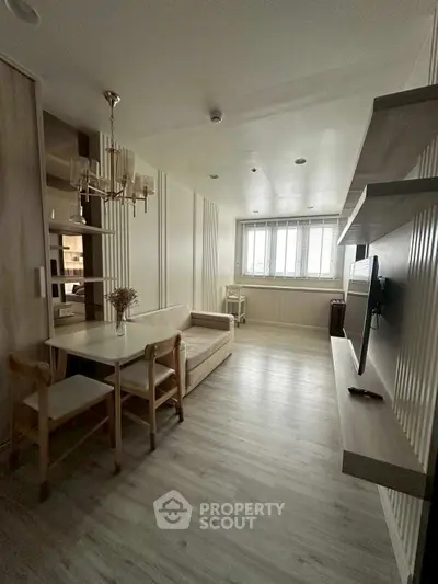 Modern living room with sleek design, featuring a cozy sofa, dining table, and wall-mounted TV, perfect for urban living.