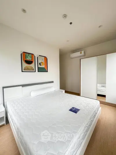 Modern bedroom with minimalist decor and large bed in a bright apartment.