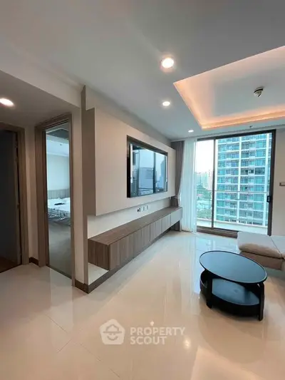 Modern living room with sleek design and city view, featuring a wall-mounted TV and stylish furniture.