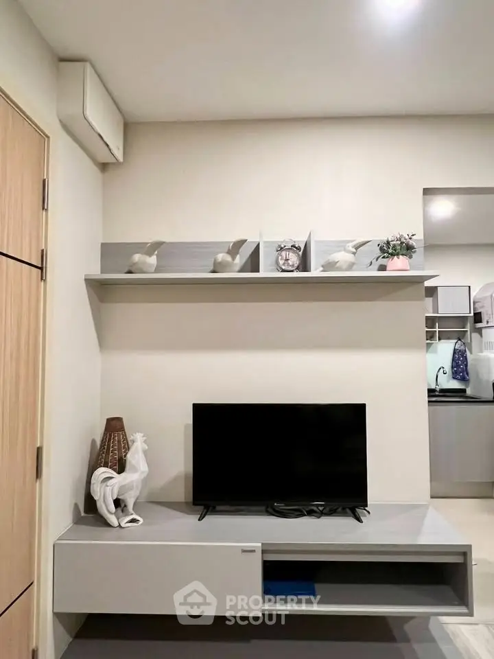Modern living room with sleek TV stand and decorative shelving in a stylish apartment.