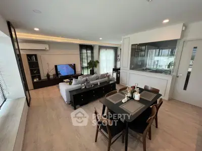 Spacious modern living room with open dining area and sleek kitchen design.