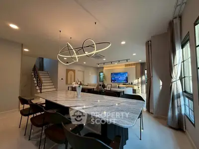 Luxurious open-plan living room with modern lighting and elegant dining area