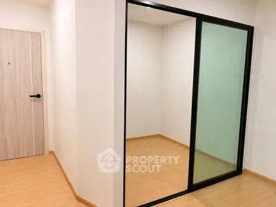 Modern interior with sliding glass door and wooden flooring, perfect for storage or small office space.