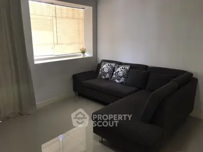 Modern living room with sleek dark sofa and large window