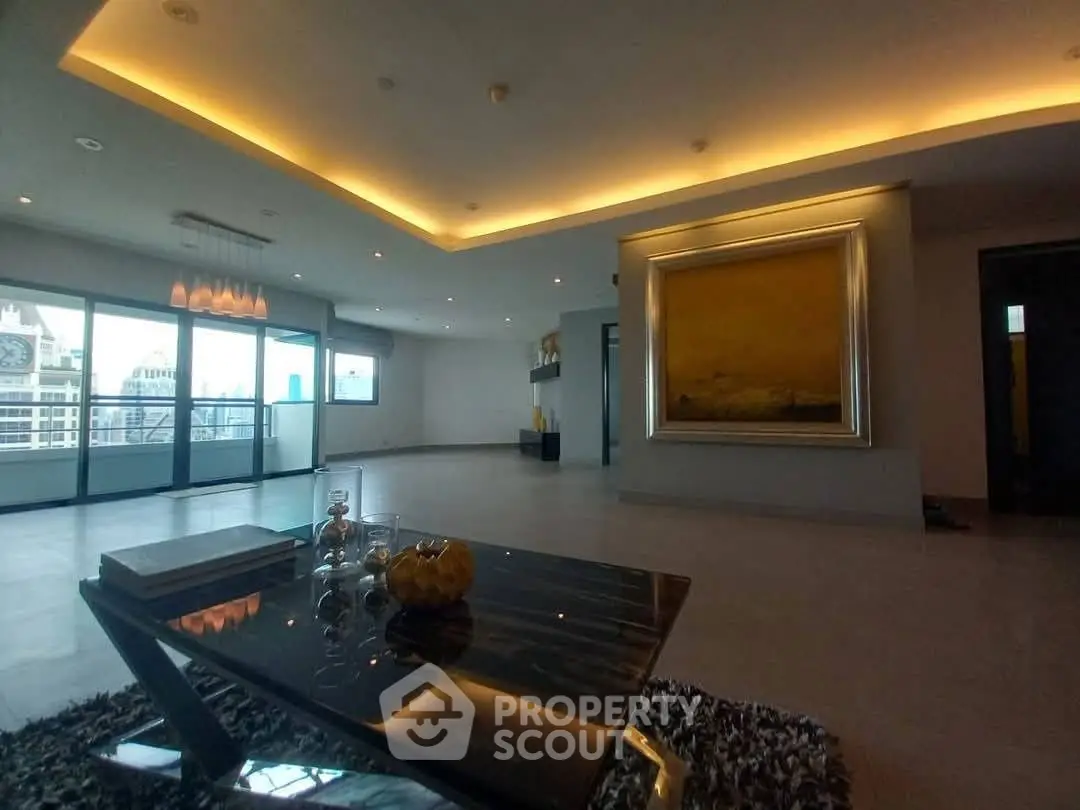 Spacious modern living room with elegant lighting and city view balcony.