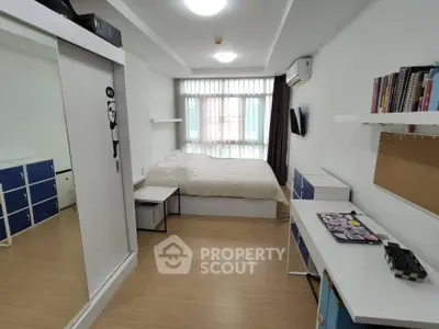 Modern bedroom with minimalist design, featuring a cozy bed, ample storage, and natural light from large window.