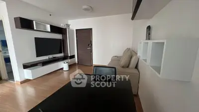 Modern living room with sleek furniture and wall-mounted TV in a stylish apartment.