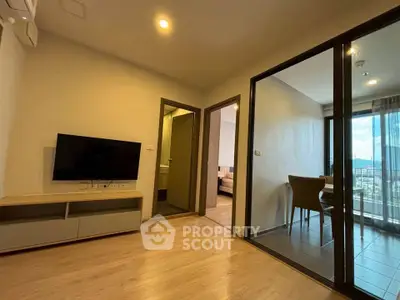 Modern apartment interior with living room and dining area, featuring sleek wooden flooring and natural light.