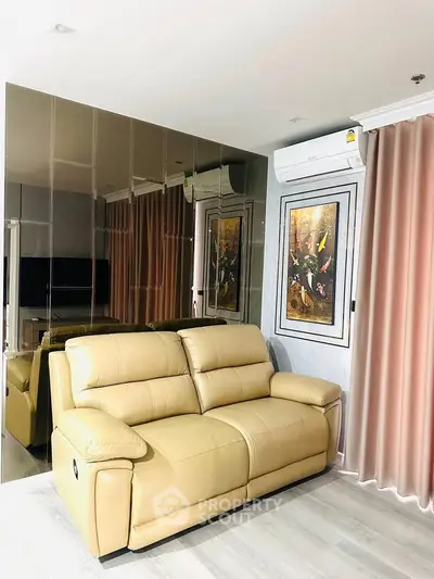 Stylish living room with beige leather sofa and mirrored wall accent