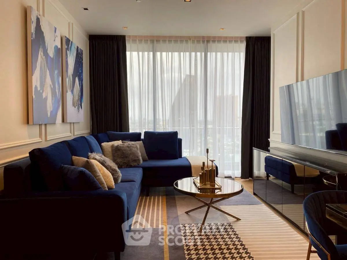 Luxurious living room with modern blue sofa and large TV, perfect for relaxation.