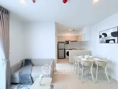 Modern open-layout living room and kitchen with stylish decor and dining area.