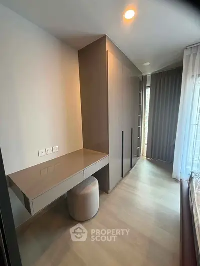 Modern bedroom with sleek wardrobe and stylish desk in a contemporary apartment.