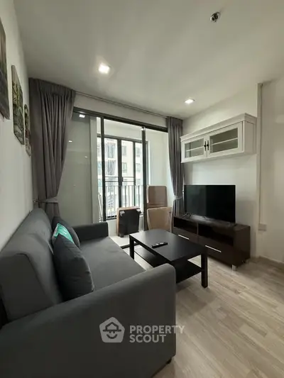 Modern living room with sleek furniture and balcony view in a stylish apartment.