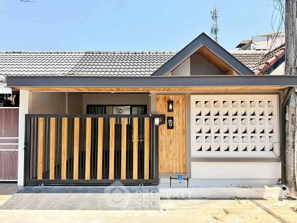 Charming modern house exterior with wooden accents and gated entrance in a serene neighborhood.