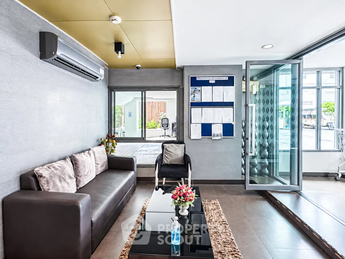 Modern lobby with sleek design, glass entrance, and comfortable seating in a contemporary building.