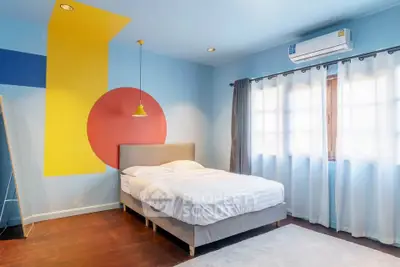 Modern bedroom with colorful wall art and natural light