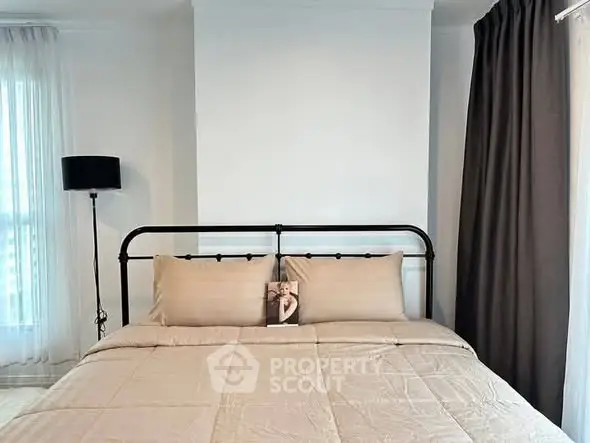 Cozy bedroom with stylish bed and elegant curtains, perfect for relaxation.