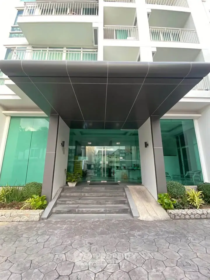 Modern apartment building entrance with sleek design and glass facade, showcasing urban living elegance.