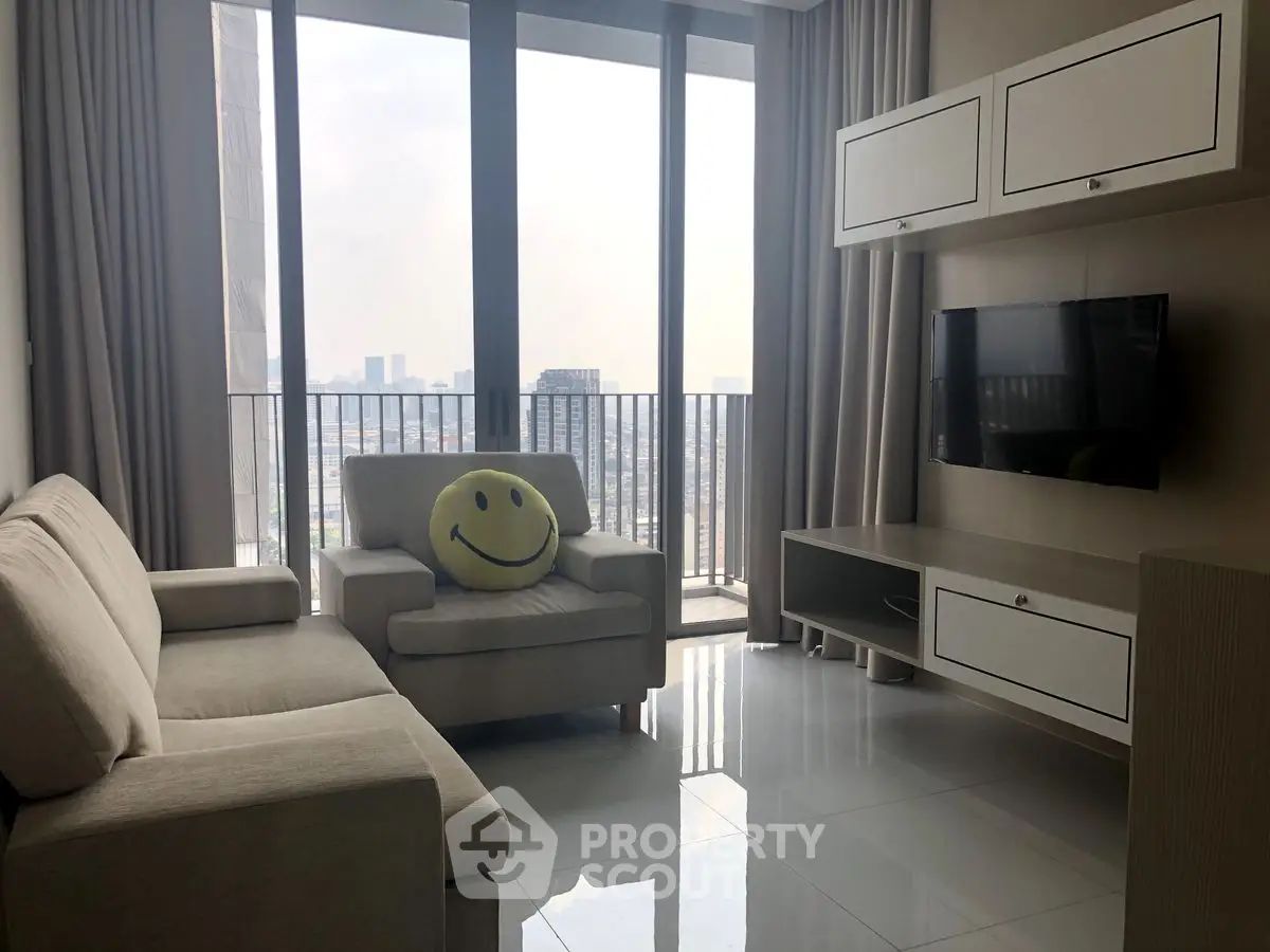 Modern living room with city view, featuring cozy seating and wall-mounted TV.
