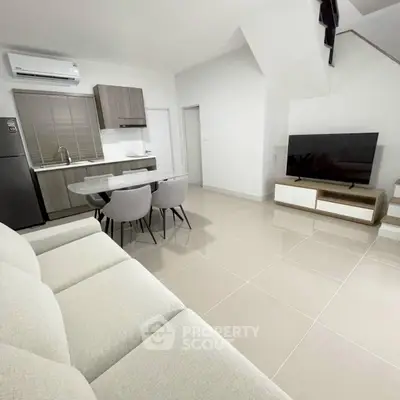 Modern open-plan living room with sleek kitchen and stylish furniture