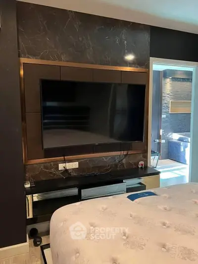 Luxurious bedroom with modern TV setup and elegant decor