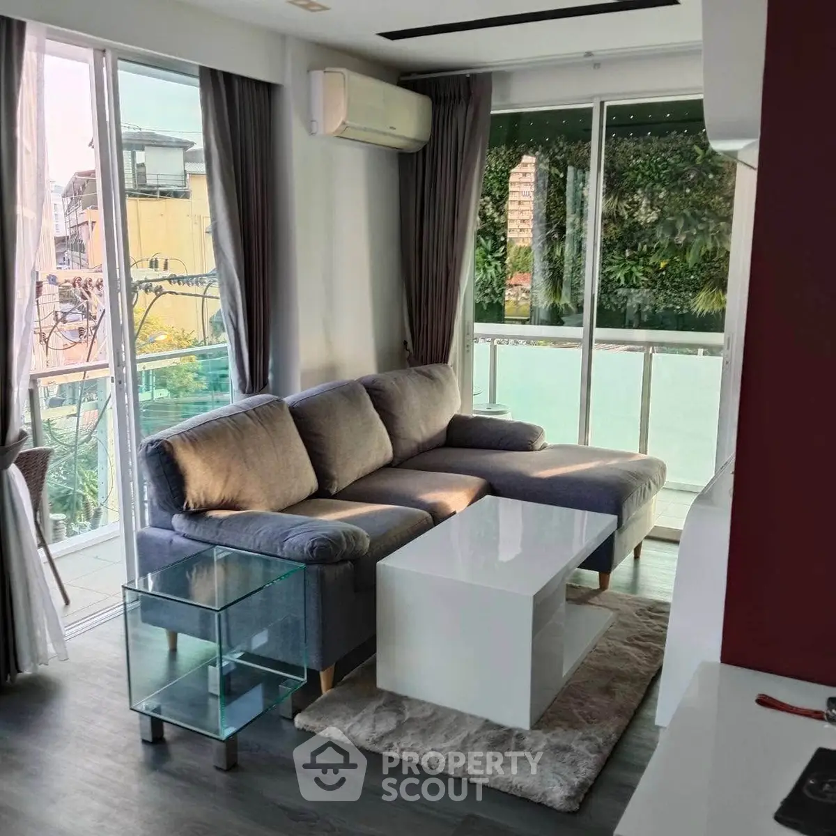 Modern living room with cozy sofa and large windows overlooking balcony