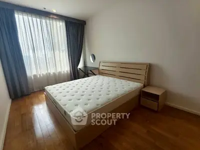 Bright and cozy bedroom with wooden flooring and large window