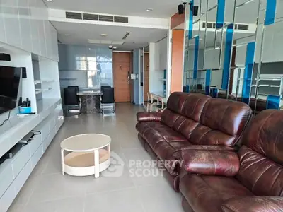 Spacious living room with leather sofa and modern entertainment unit in a stylish apartment.