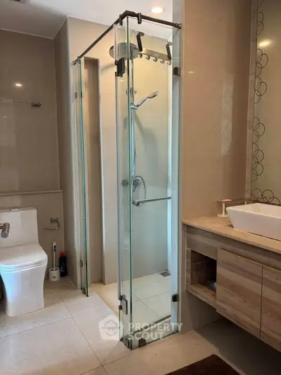 Modern bathroom with glass shower, sleek vanity, and contemporary toilet design.
