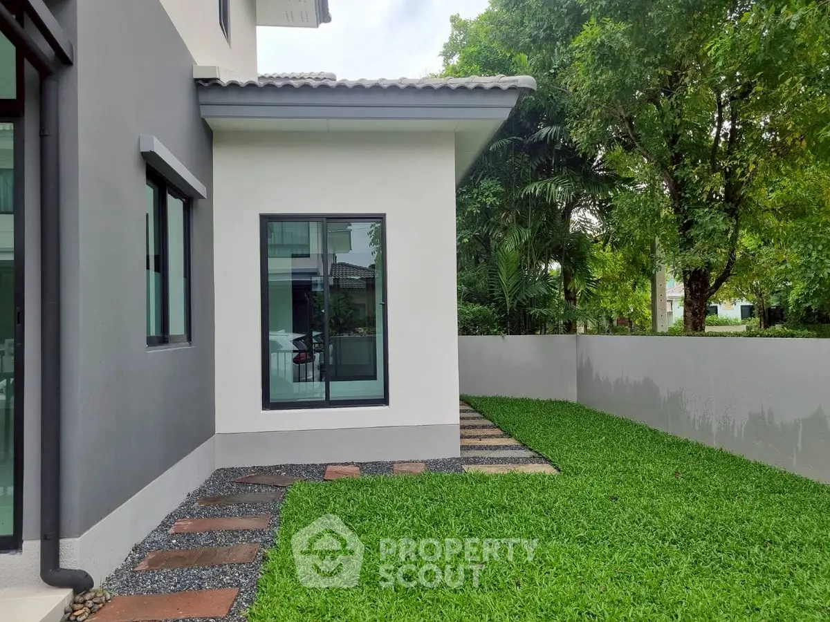 Modern house exterior with lush green lawn and pathway