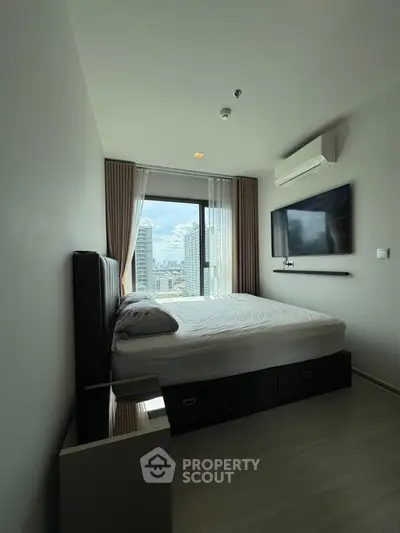 Modern bedroom with city view, featuring sleek design and wall-mounted TV.