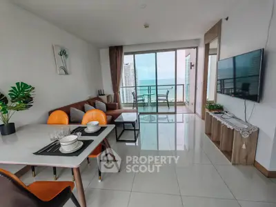 Modern living room with ocean view, stylish decor, and spacious balcony in luxury apartment.