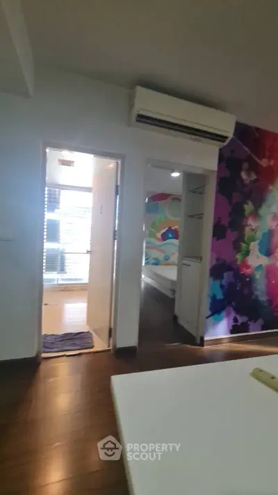 Modern apartment interior with colorful wall art and air conditioning unit