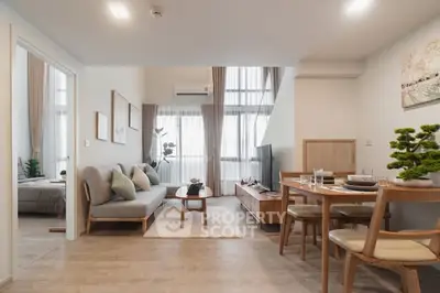 Modern living room with stylish decor and open layout, featuring a cozy dining area and natural light.