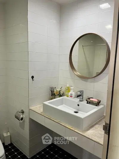 Modern bathroom with stylish round mirror and sleek white sink