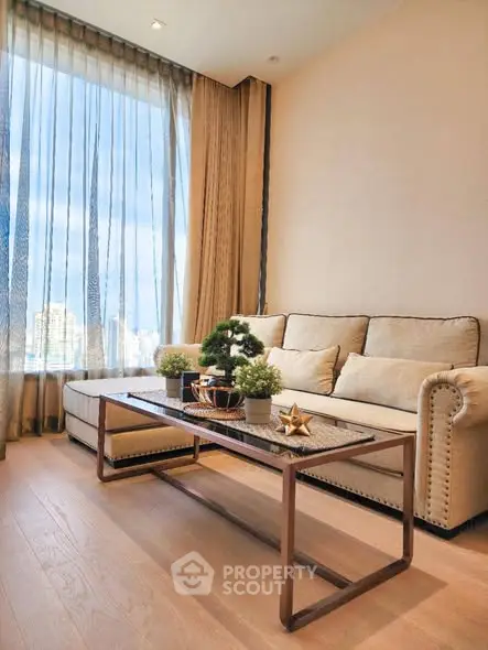 Elegant living room with plush sofa and city view through large windows.