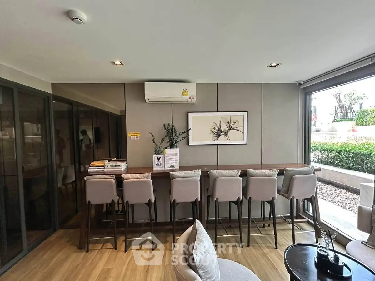Modern communal area with stylish seating and large windows in a contemporary building.