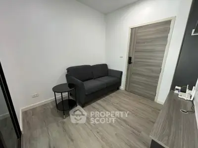 Modern living room with sleek gray sofa and wooden flooring, perfect for cozy urban living.