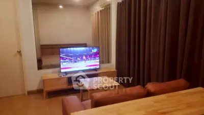 Cozy living room with modern TV setup and warm wooden furniture