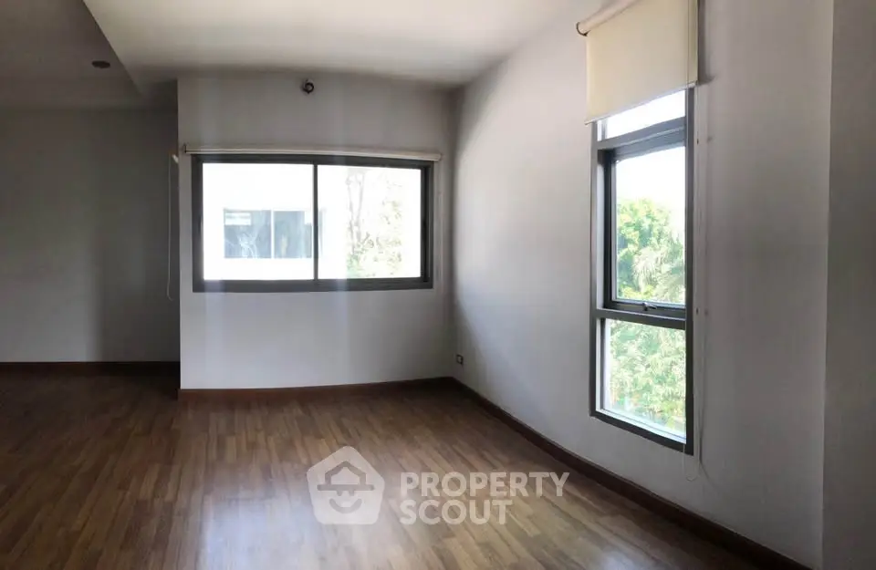 Spacious corner unit with large windows and wooden flooring, offering abundant natural light.