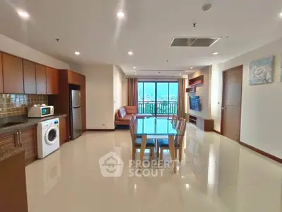 Spacious open-plan living room with modern kitchen and city view balcony.
